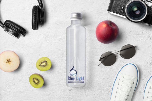 mockup-featuring-a-glass-water-bottle-placed-on-a-clear-surface-and-surrounded-by-different-items-3155-el1